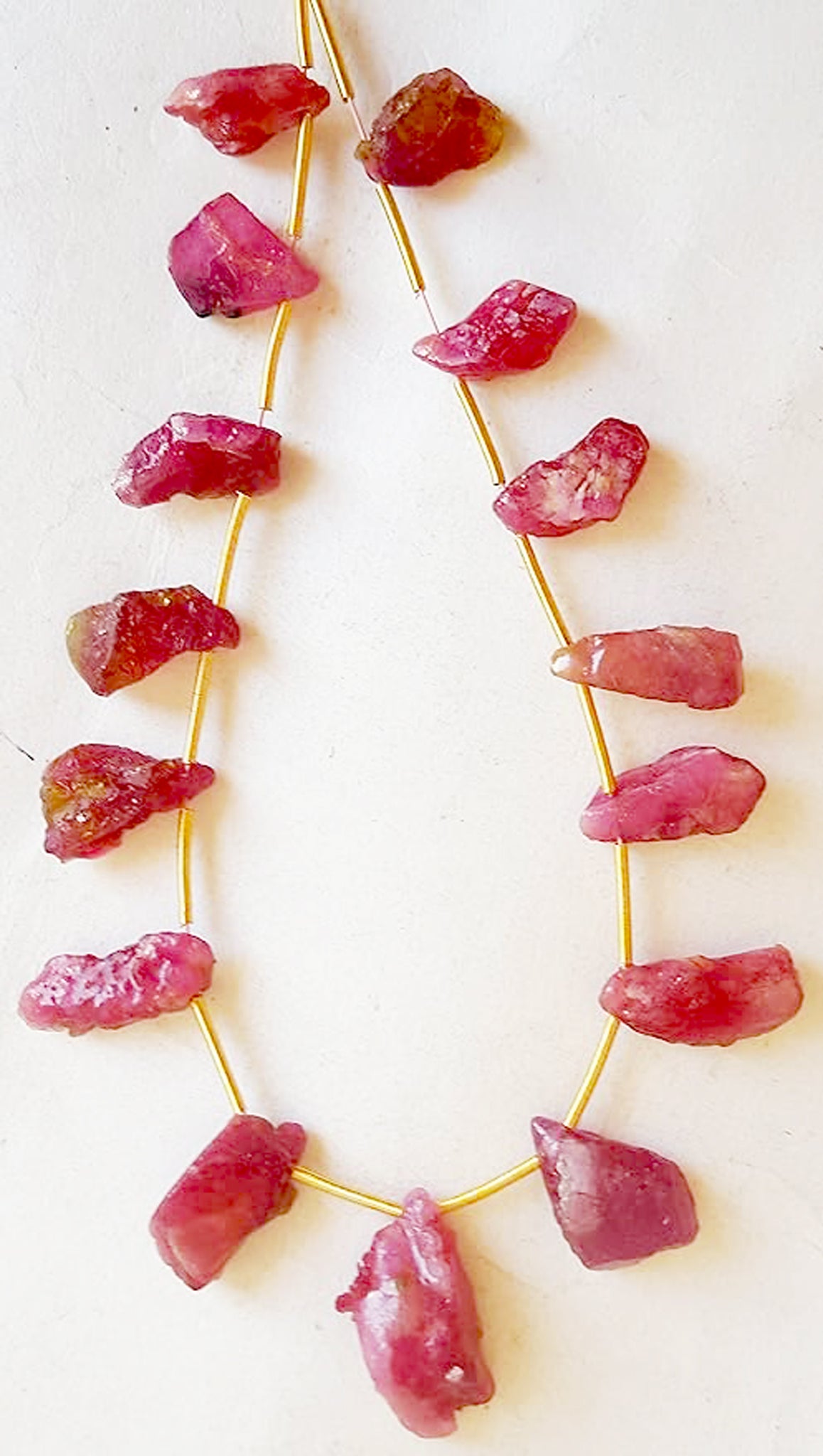 Cluster of 15 ruby beads showcasing irregular shapes and rich red colour intensity.