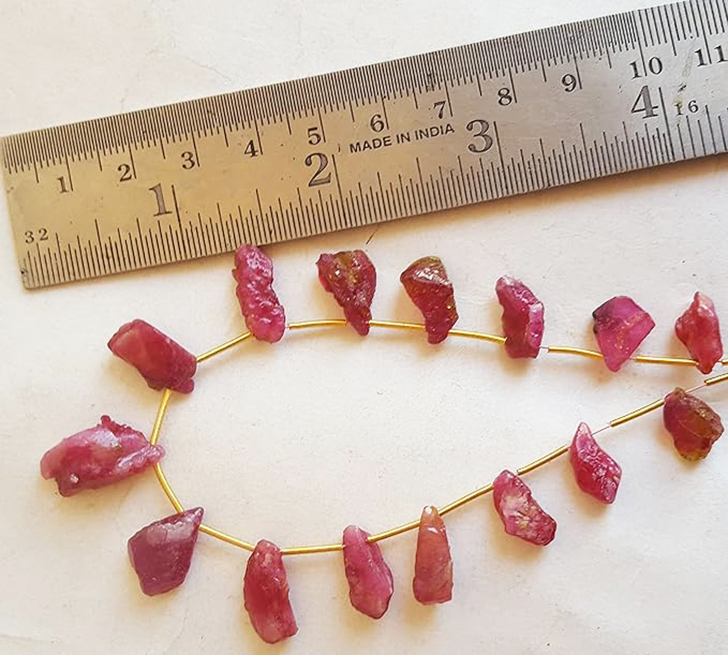 A rulers measures the ruby rough side drill gemstone.