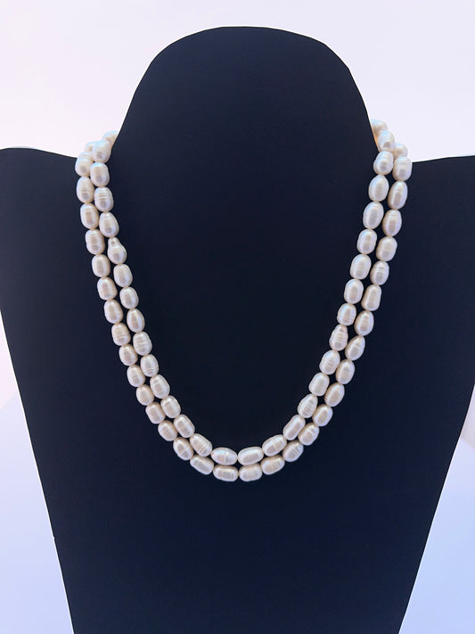 Close‑up of 7.5–8mm textured oval pearls arranged on a polished freshwater pearl necklace.