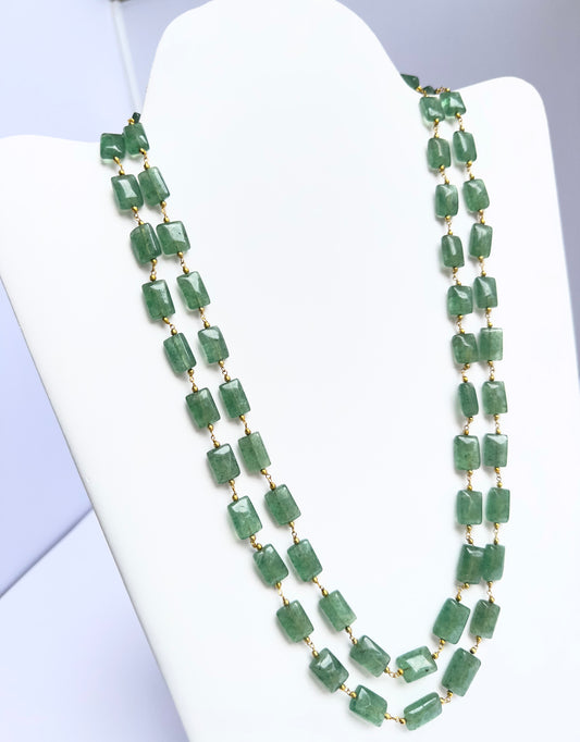 Close-up of quartz gemstone beads, rectangular cut, smooth clarity, arranged in dual strands.