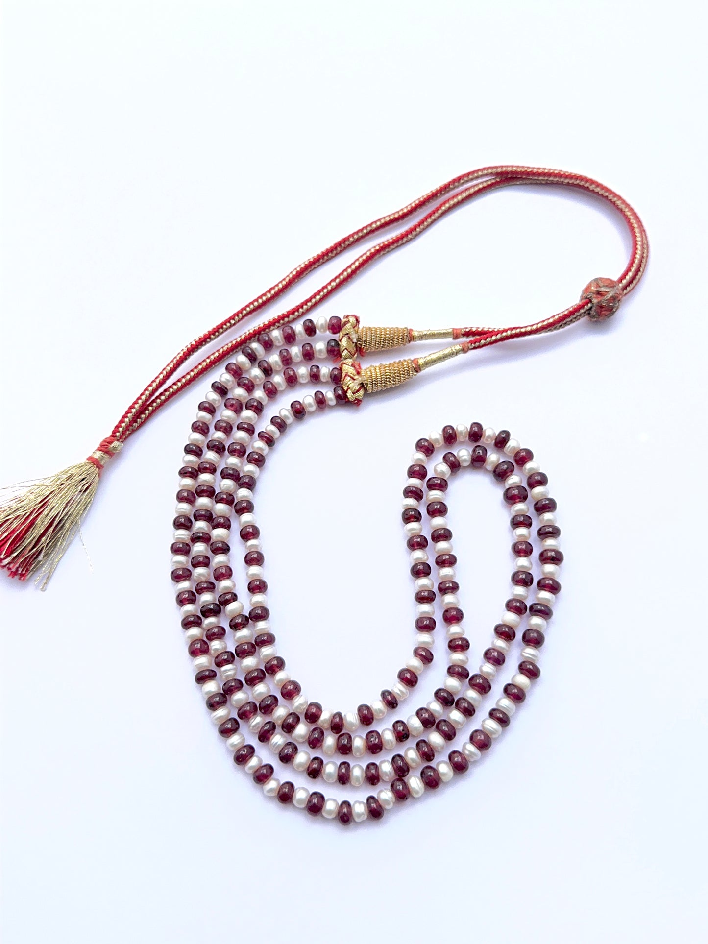 Elegant ruby and pearl necklace featuring polished rondelle beads in a layered design.