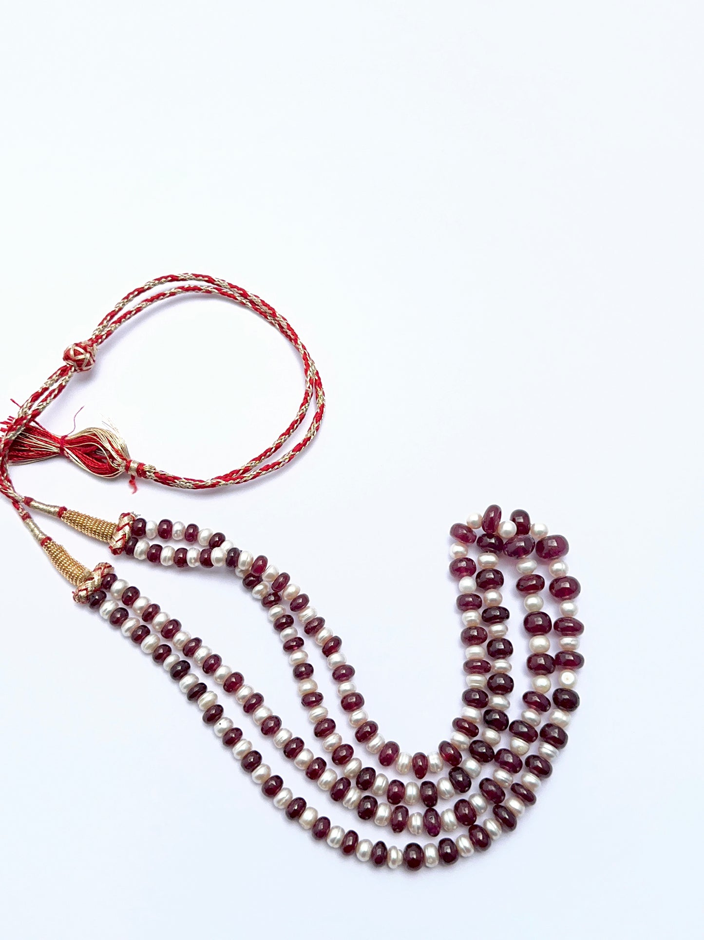 Elegant ruby and pearl necklace featuring polished rondelle beads in a balanced layout.