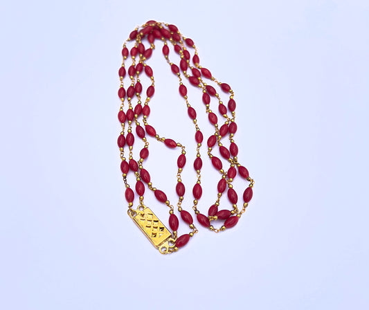 Close-up of Taiwan coral necklace featuring smooth drum cut stone beads, vibrant red colour and polished shine.