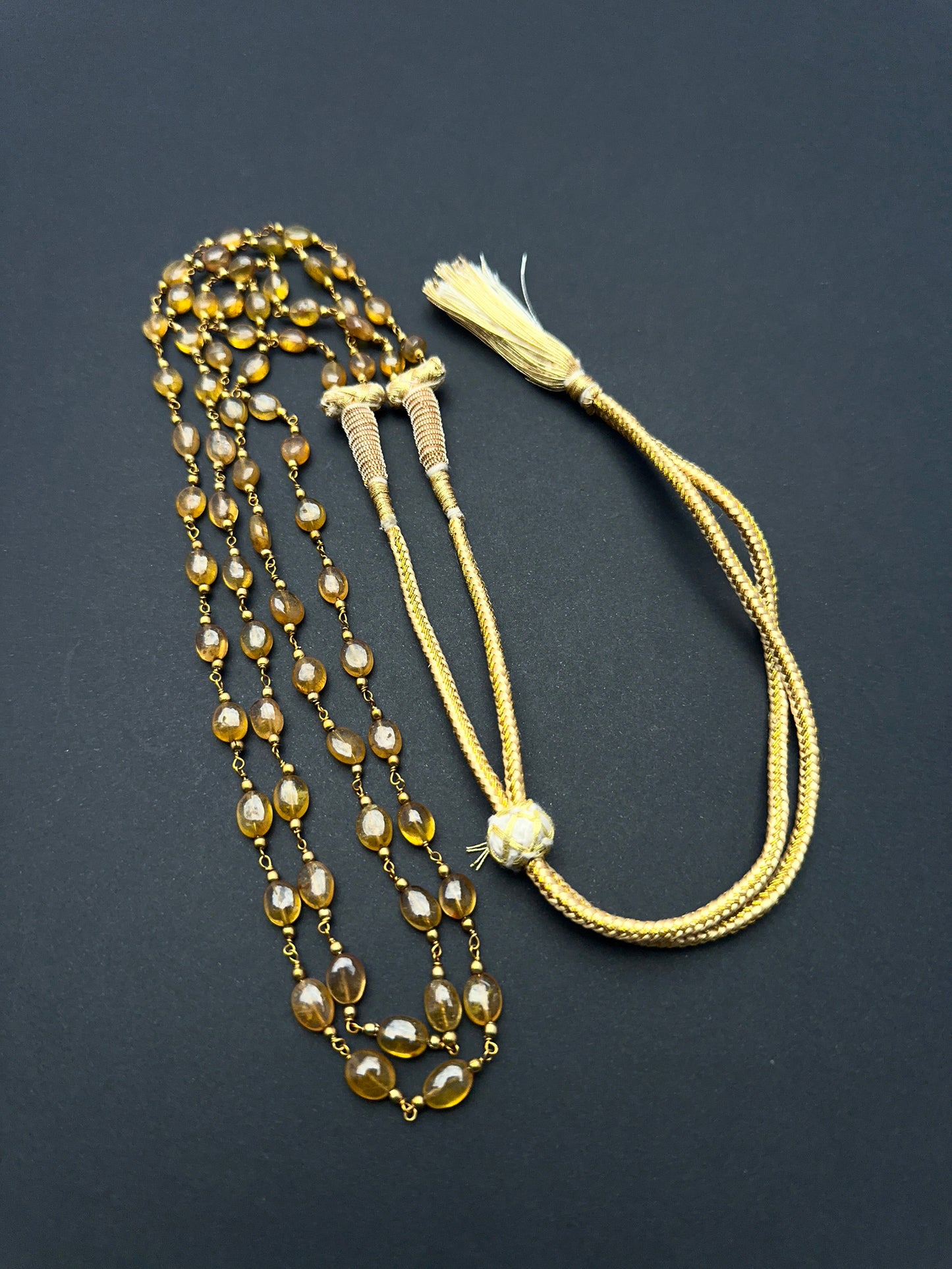 Elegant gemstone necklace featuring polished yellow sapphire beads in a layered design.