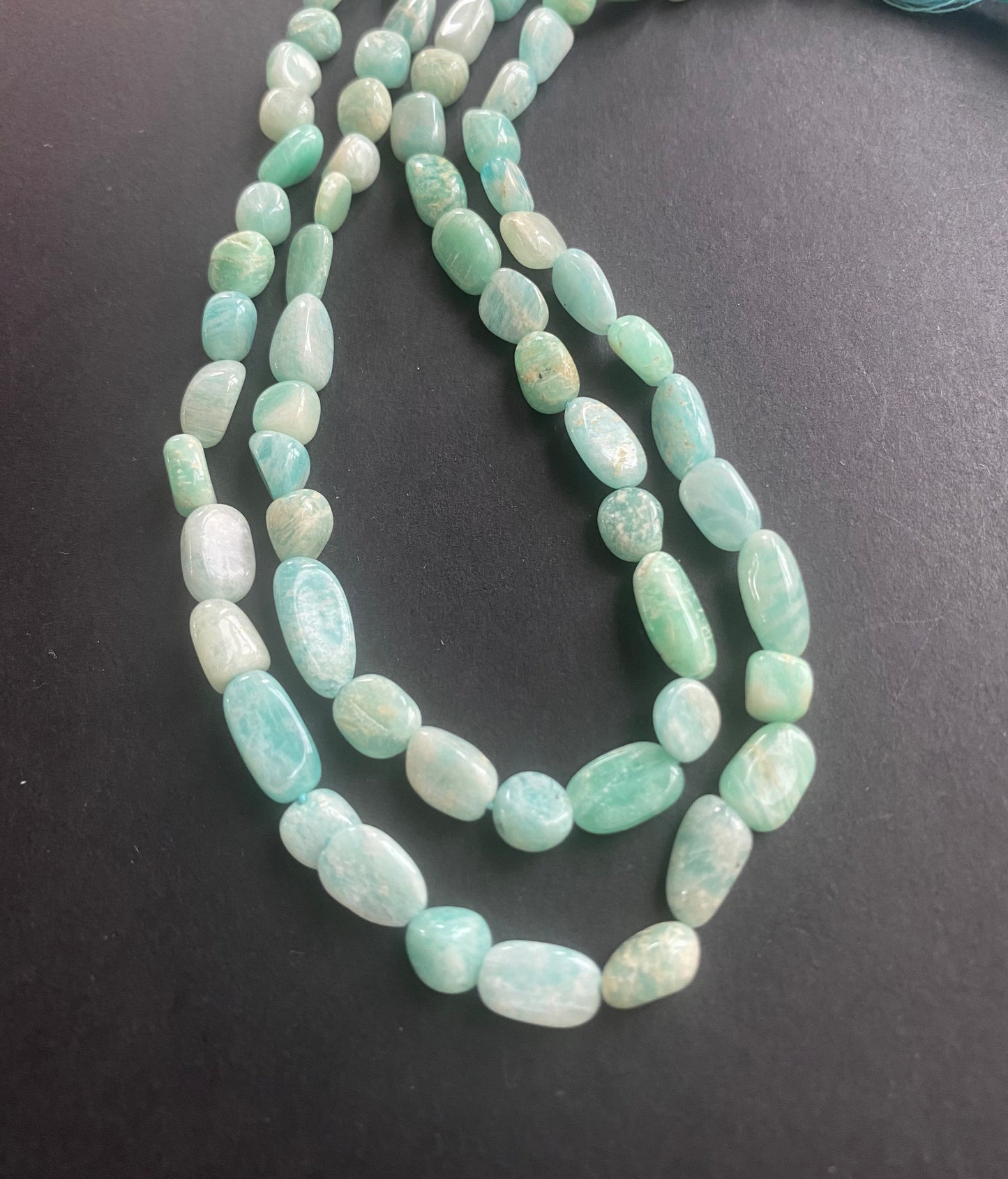 Strand featuring 5mm to 6.5mm tumble smooth beads in a vibrant green colour, showcasing the beauty of Amazonite.