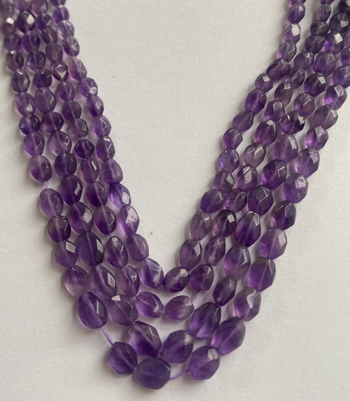 Elegant strands adorned with 5.5mm to 6.5mm faceted teardrop amethyst stones, showcasing a rich purple colour.