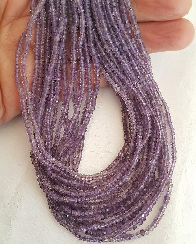 Close-up of a person holding a stunning purple amethyst gemstone strand, highlighting its intricate facets.