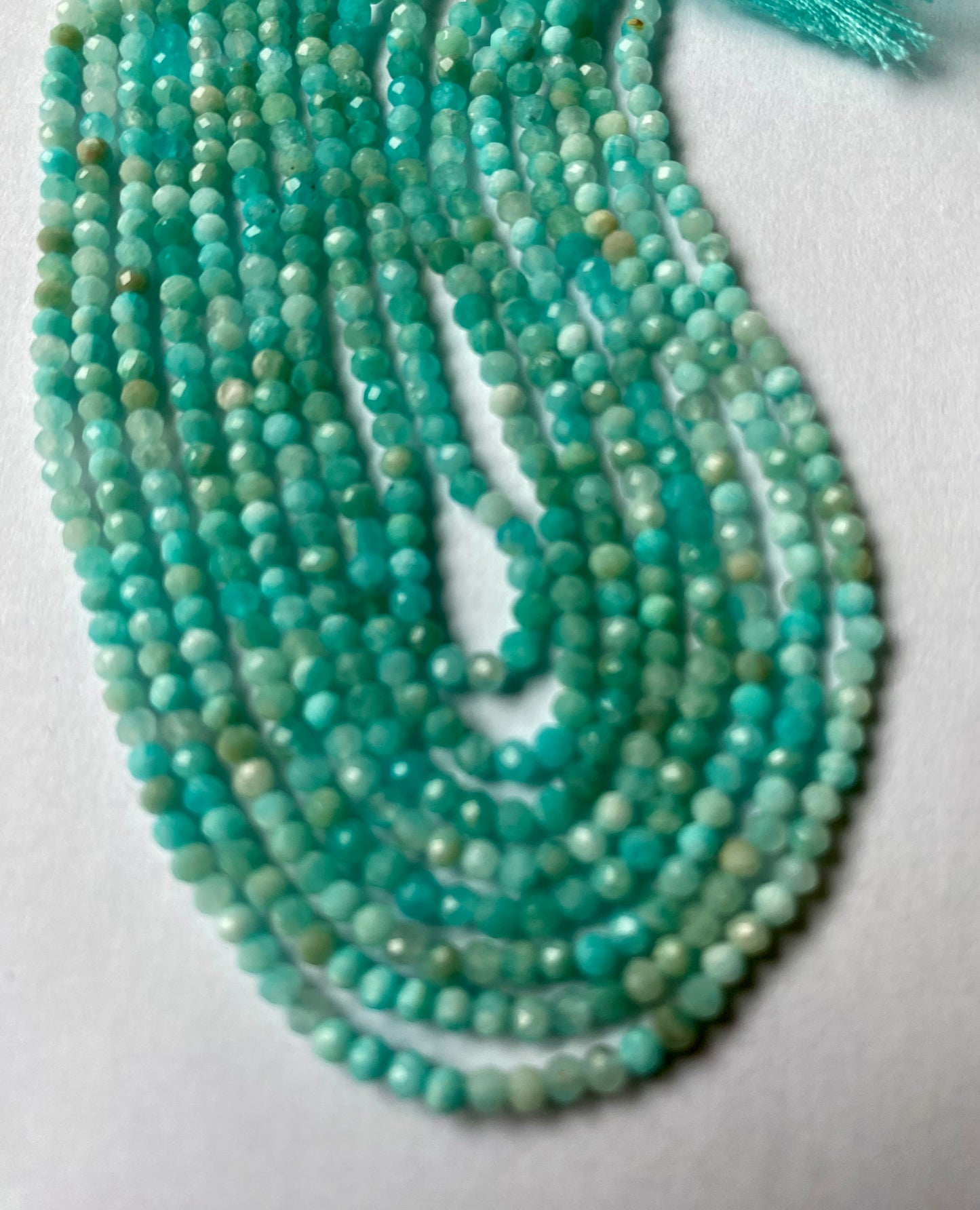 A collection of faceted Aquamarine beads, showcasing their stunning Aqua green brilliance.