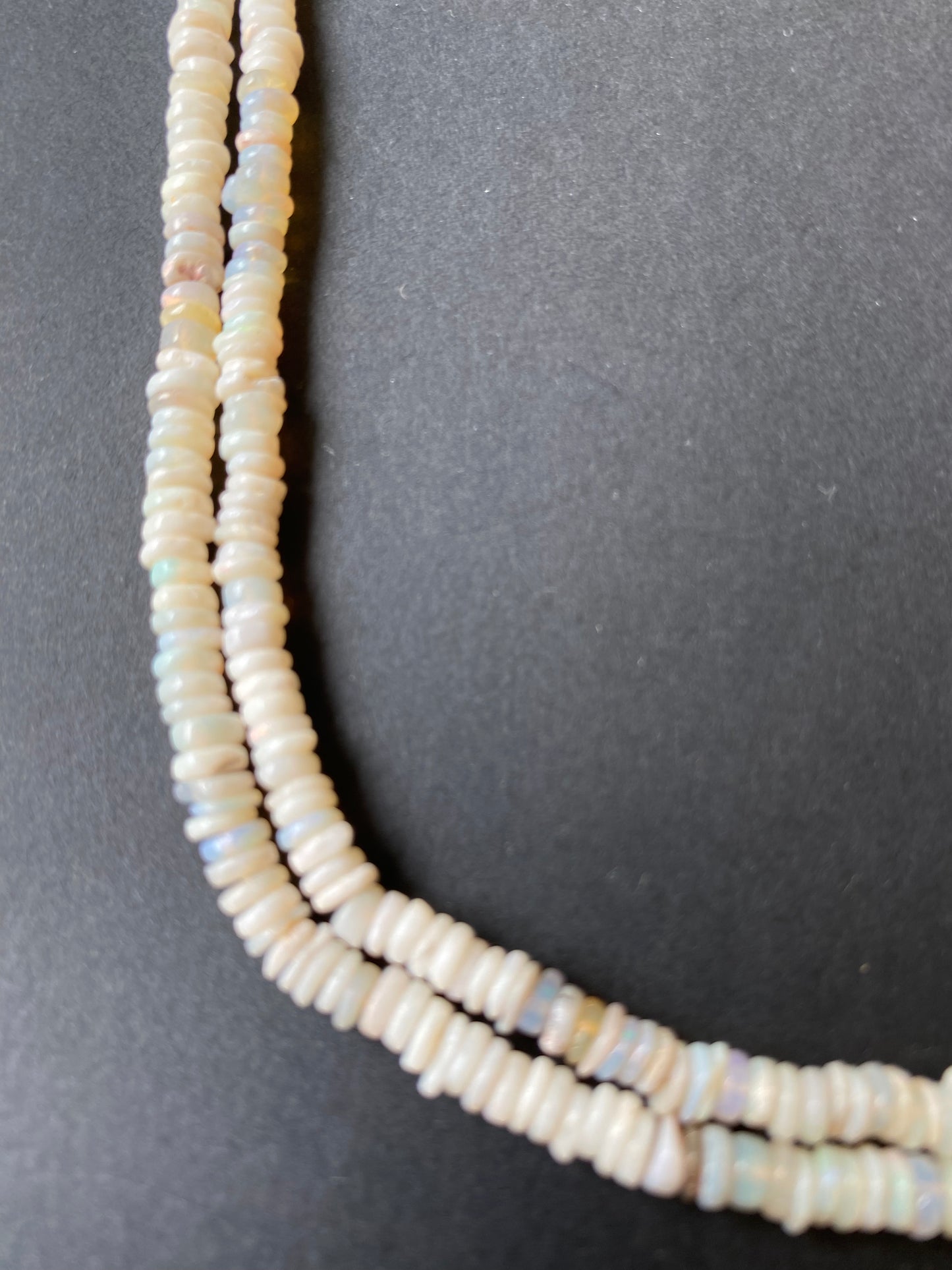 Elegant gemstone strand adorned with 4-4.5mm smooth white opal beads, highlighting the beauty of Australian opals.