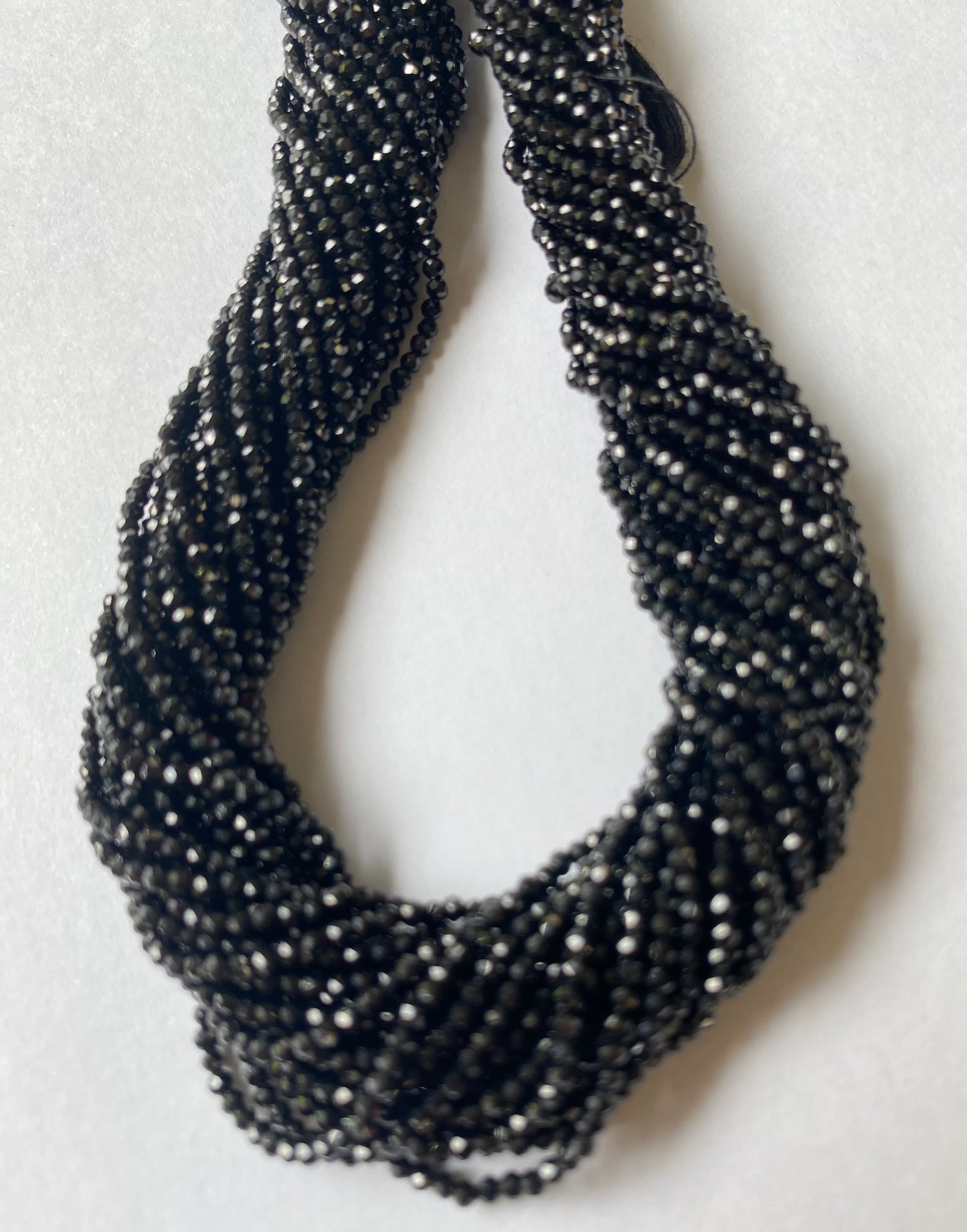 Elegant strands adorned with 2-2.5mm black spinel micro-faceted rondelle beads, showcasing a sleek design.