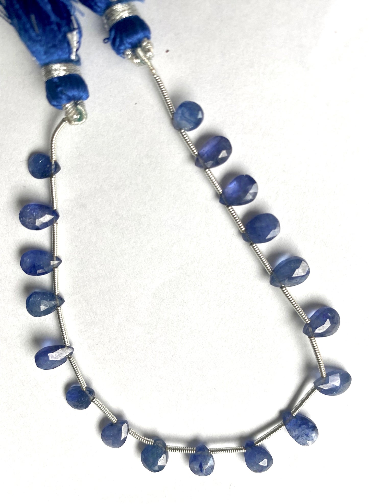 Beautiful strand of precious blue sapphire gemstone beads, featuring faceted pear almond sized between 7mm and 9mm, radiating elegance.