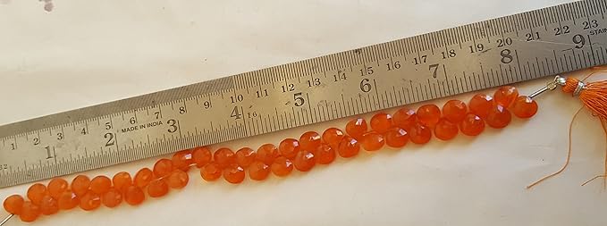 A ruler beside a cluster of Carnelian gemstone beads, measuring 8mm in size.
