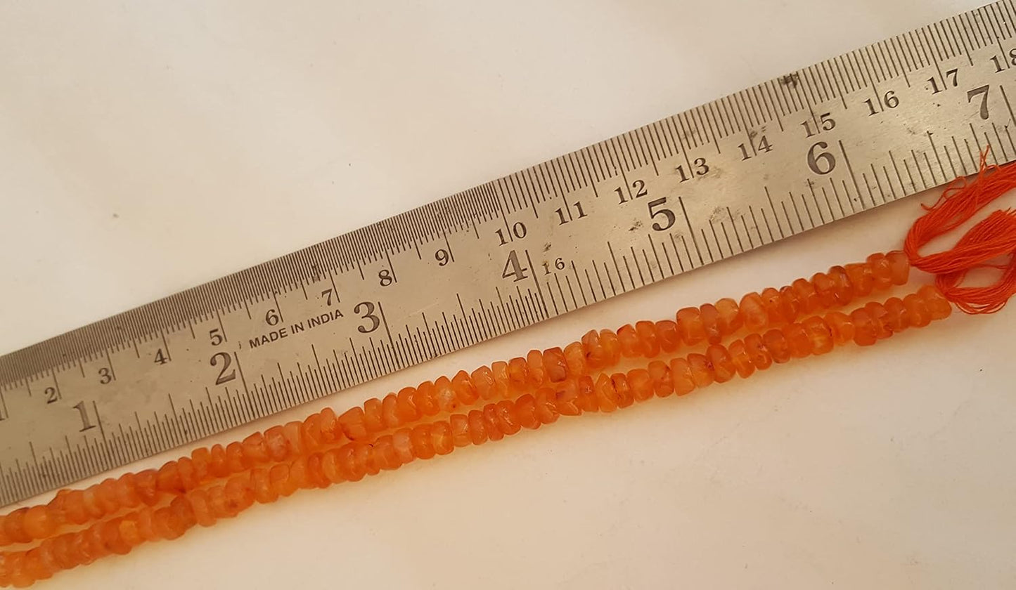 An 6mm carnelian natural stone smooth wheel bead next to a ruler for size reference.