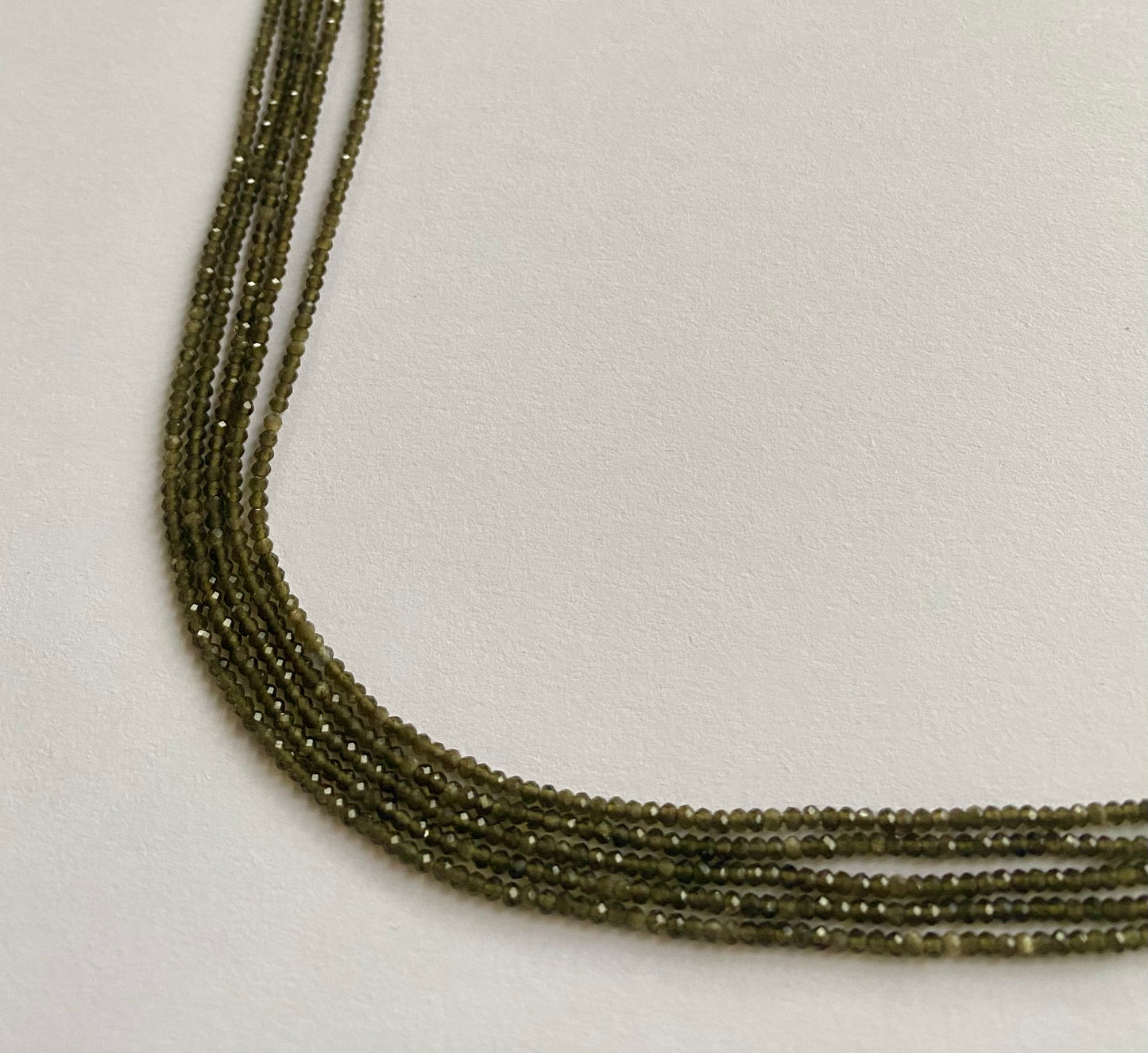 Featuring faceted cat's eye rondelle beads, 2mm in size, showcasing a beautiful green hue.