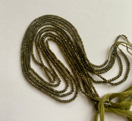 Elegant gemstone strand adorned with 2mm smooth green cat's eye beads, highlighting the beauty of gemstone.