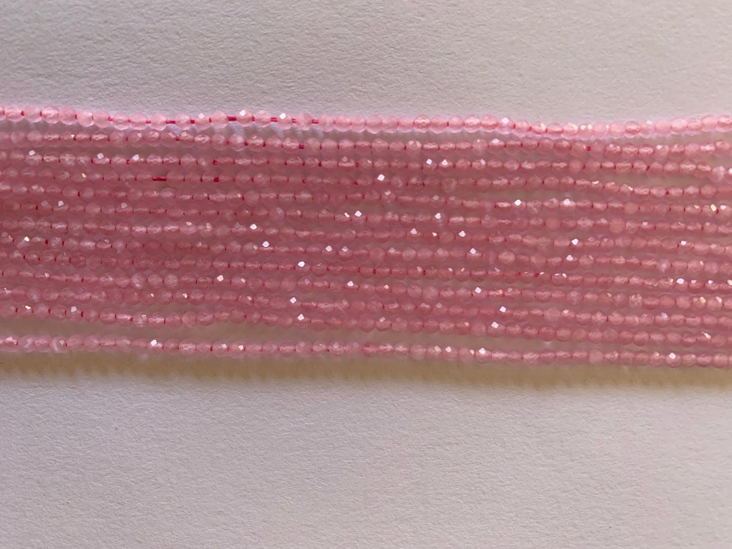 Long strands of pink chalcedony faceted rondelle beads, showcasing their natural beauty and unique colours.