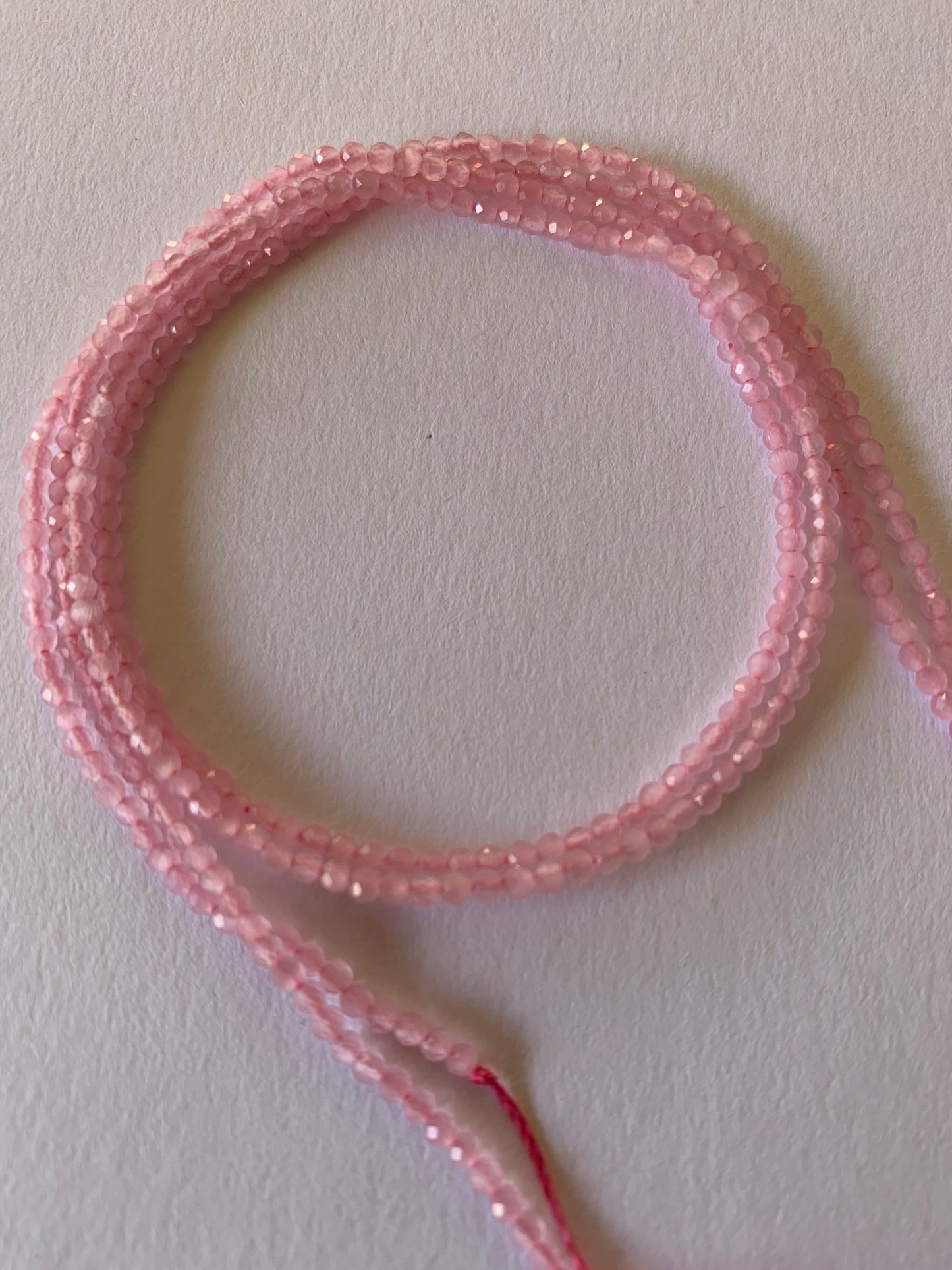 A vibrant strand of 2 to 2.2mm pink chalcedony faceted rondelle beads, highlighting their natural elegance and charm.