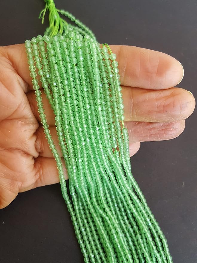 Strands of green chalcedony beads, featuring 2.5mm faceted rondelle shapes, showcasing their vibrant colour and shine in a wholesale bulk bunch.
