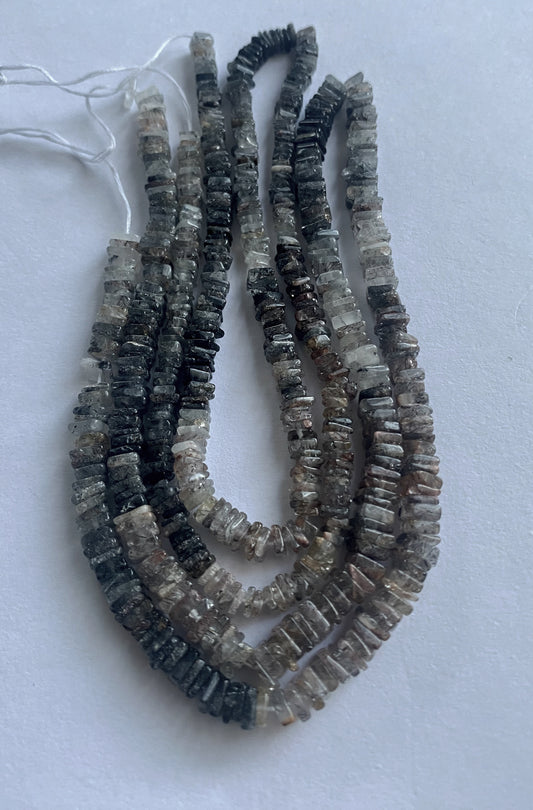 Close-up of polished 4-5.5mm square cut Change Garnet beads with deep red-purple tones.