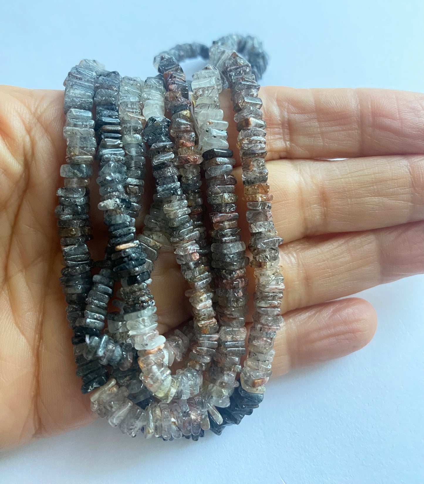 Richly coloured Change Garnet gemstone beads with a clean heishi finish, glowing under light.
