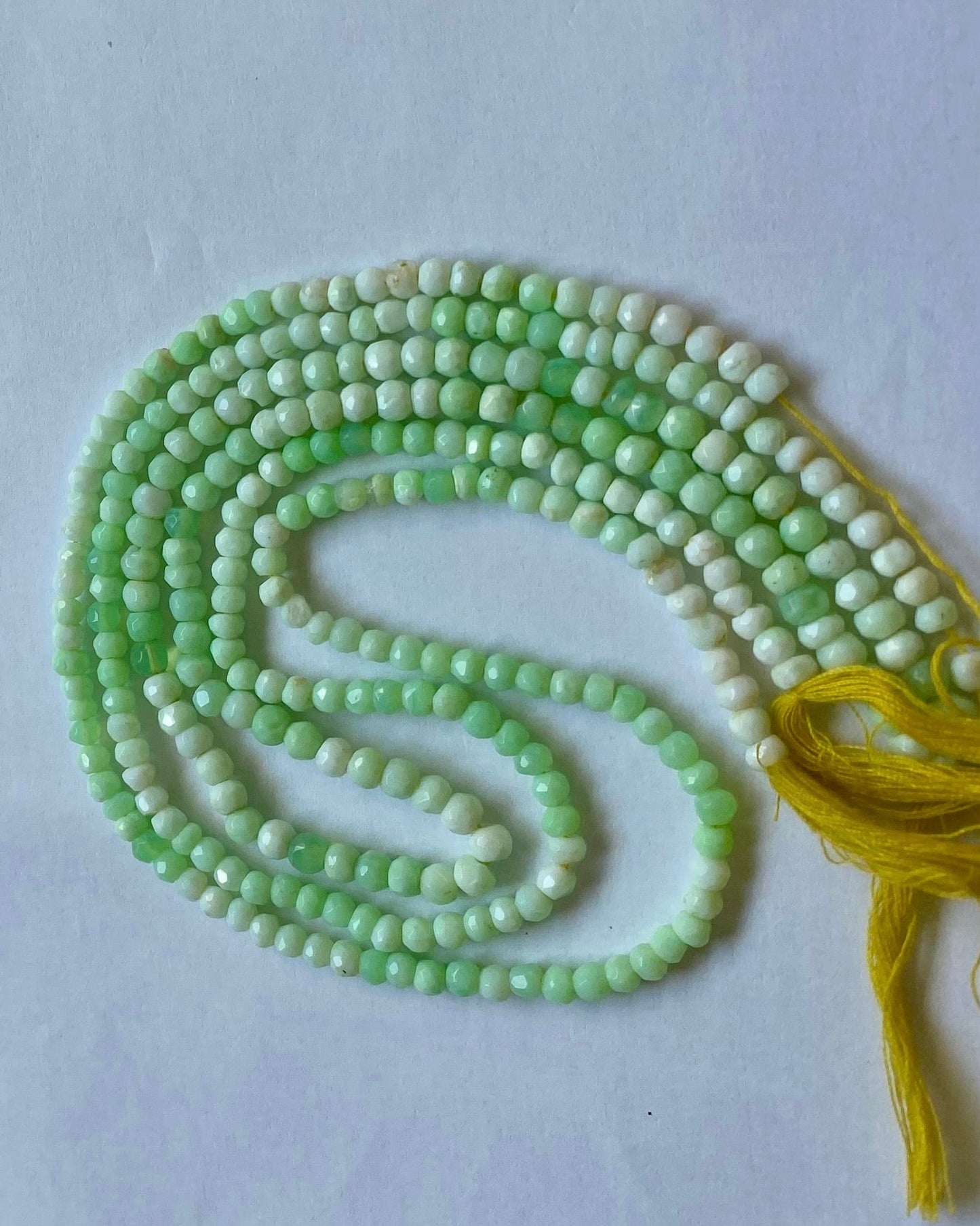 Green Chrysoprase gemstone beads in faceted rondelle shape, 4.0-4.5mm, threaded in a strand for a vibrant, elegant look.