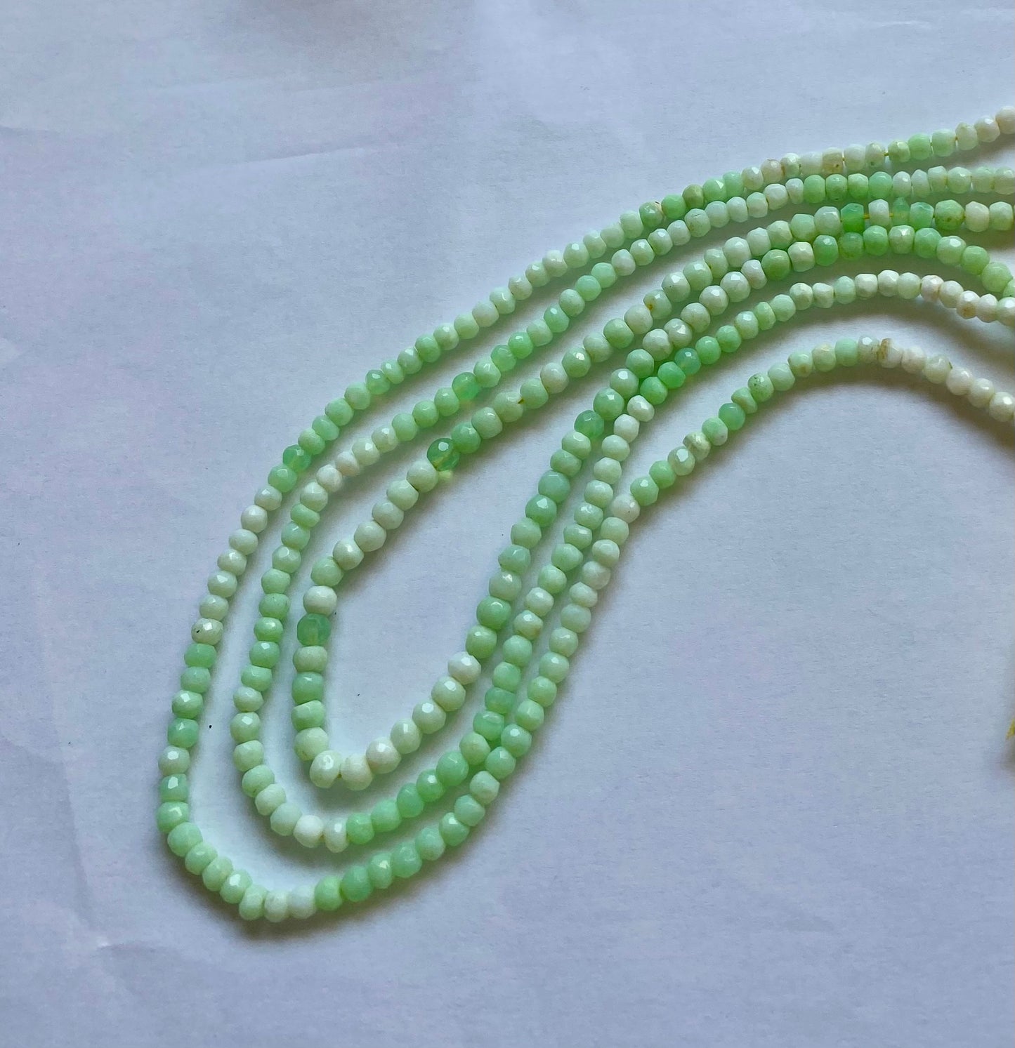 A strand of green chrysoprase beads, faceted rondelle style, measuring 4.0-4.5mm in size.