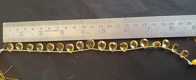 A ruler beside a faceted citrine natural gemstone bead.