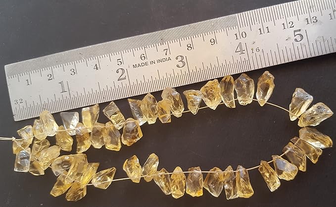 A ruler beside a cluster of yellow citrine gemstone beads, measuring 7mm to 9mm in size.