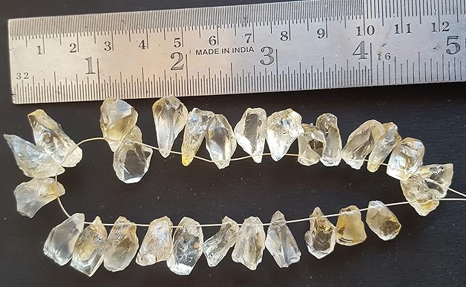 A ruler beside a cluster of yellow citrine gemstone beads, measuring 9mm to 10mm in size.