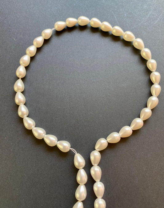Strand of natural corn pearls with a tear-drop shape.