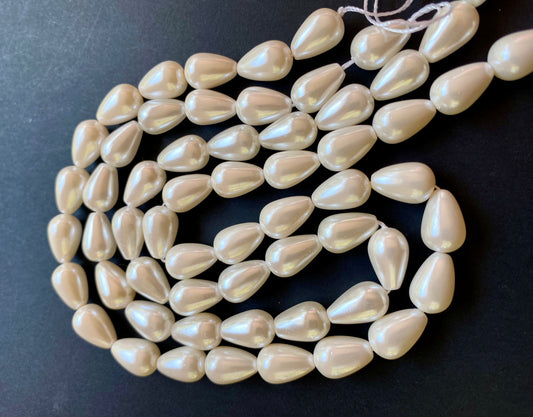 A delicate strand of cone-shaped white pearls, measuring 8-12mm, set against a contrasting black background.