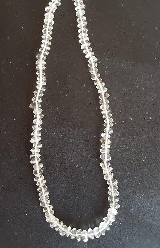 A crystal gemstone displayed on a table, highlighting its unique shape and brilliant clarity.