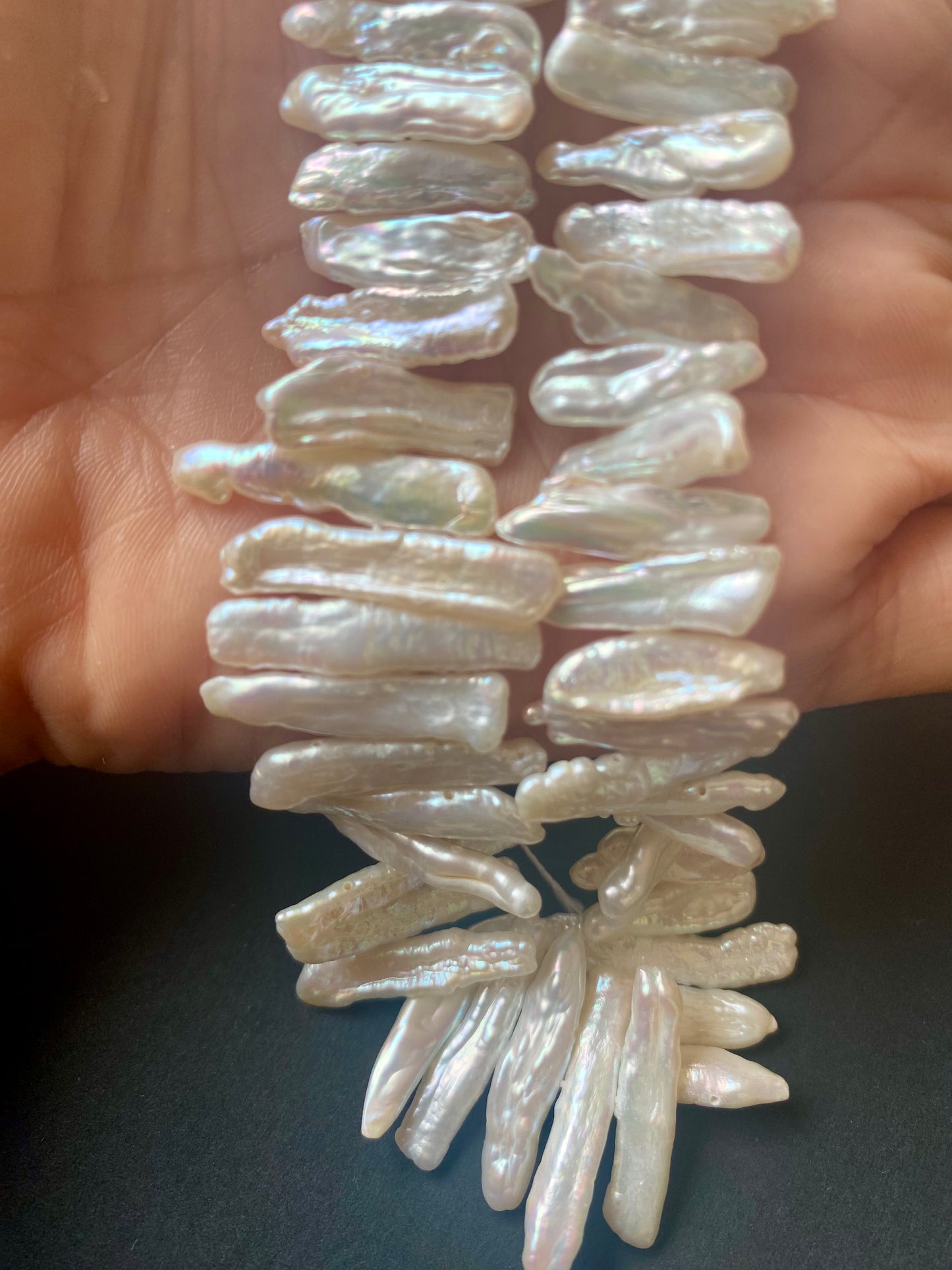 Baroque pearls strung in a flowing arrangement, reflecting light with a creamy glow.