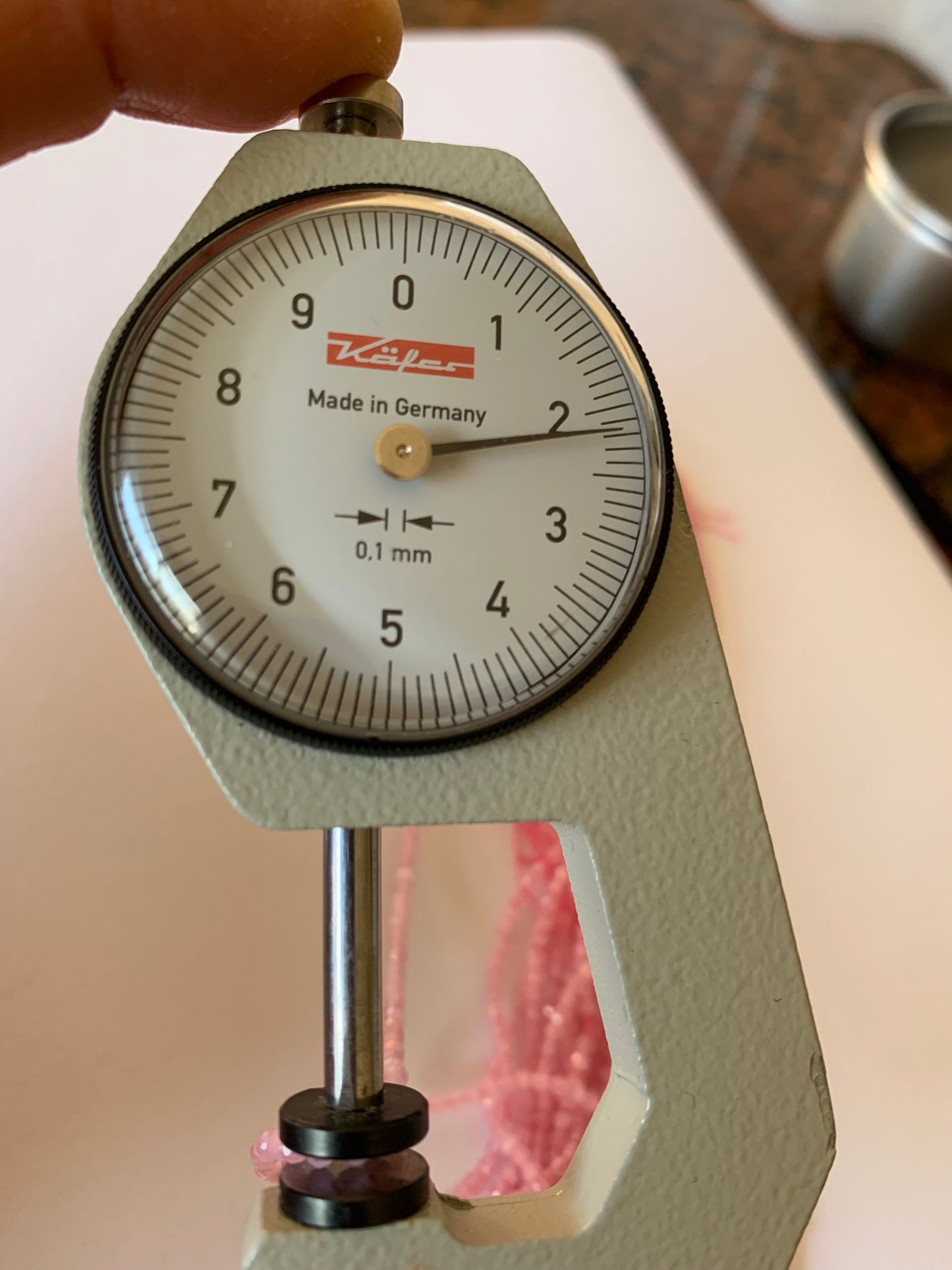 A dial gauge measures the Chalcedony Faceted Rondelle 2.0mm to 2.2mm gemstone.