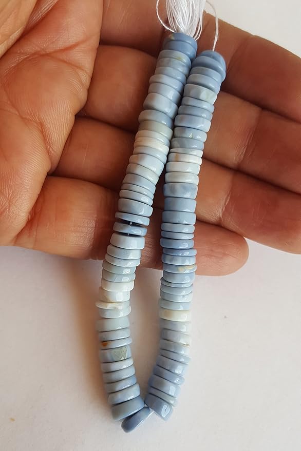 A person holds a strand made of denim opal smooth wheel beads featuring vibrant multi-coloured gemstones.