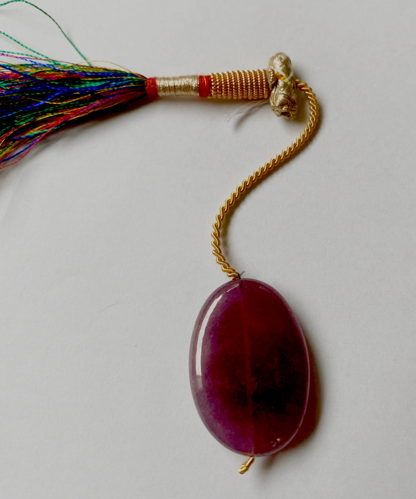 Ruby pendant positioned to showcase depth, clarity, and consistent cut with drilled hole detail.