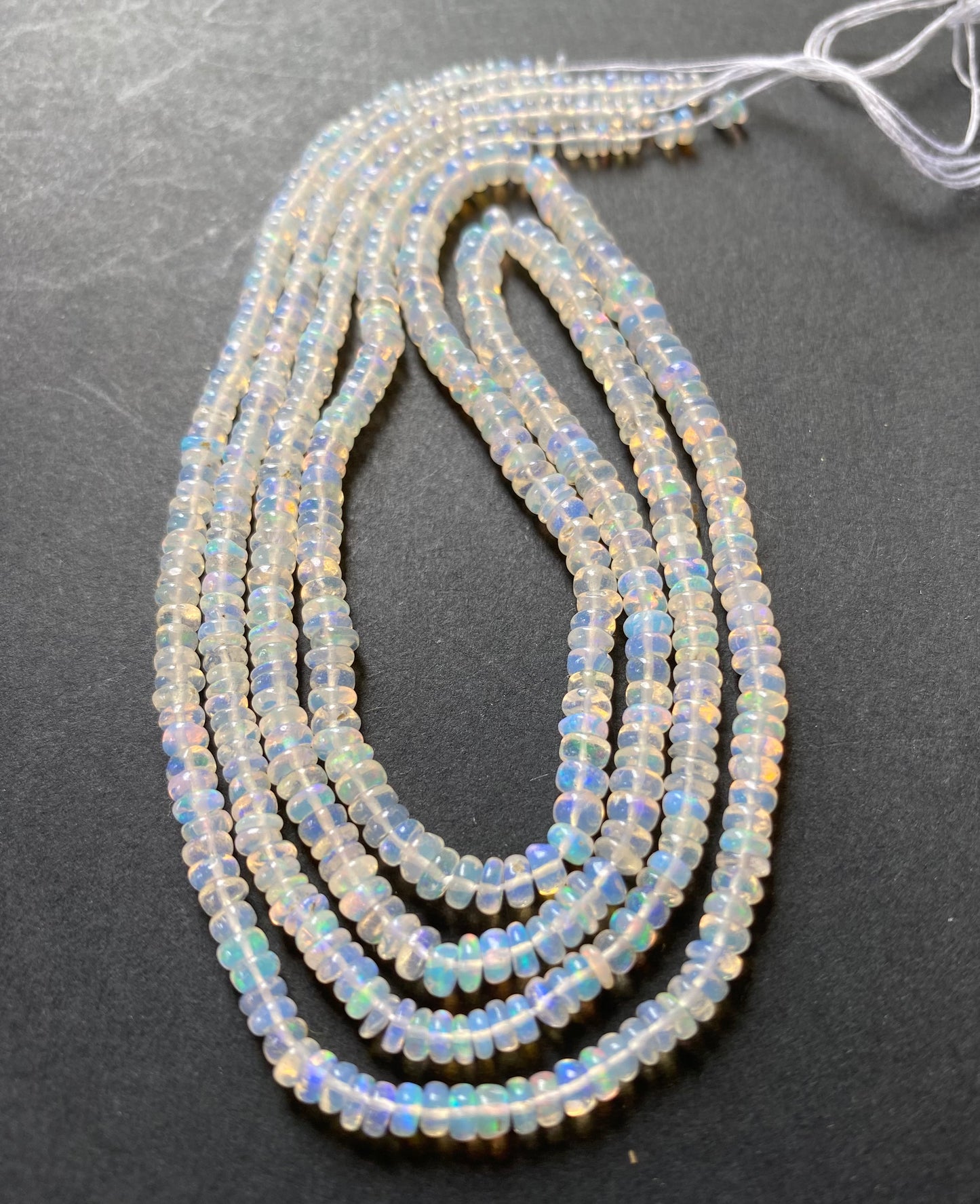 Elegant gemstone strand adorned with 3.2-4.2mm smooth white opal beads, highlighting the beauty of ethiopian opals.