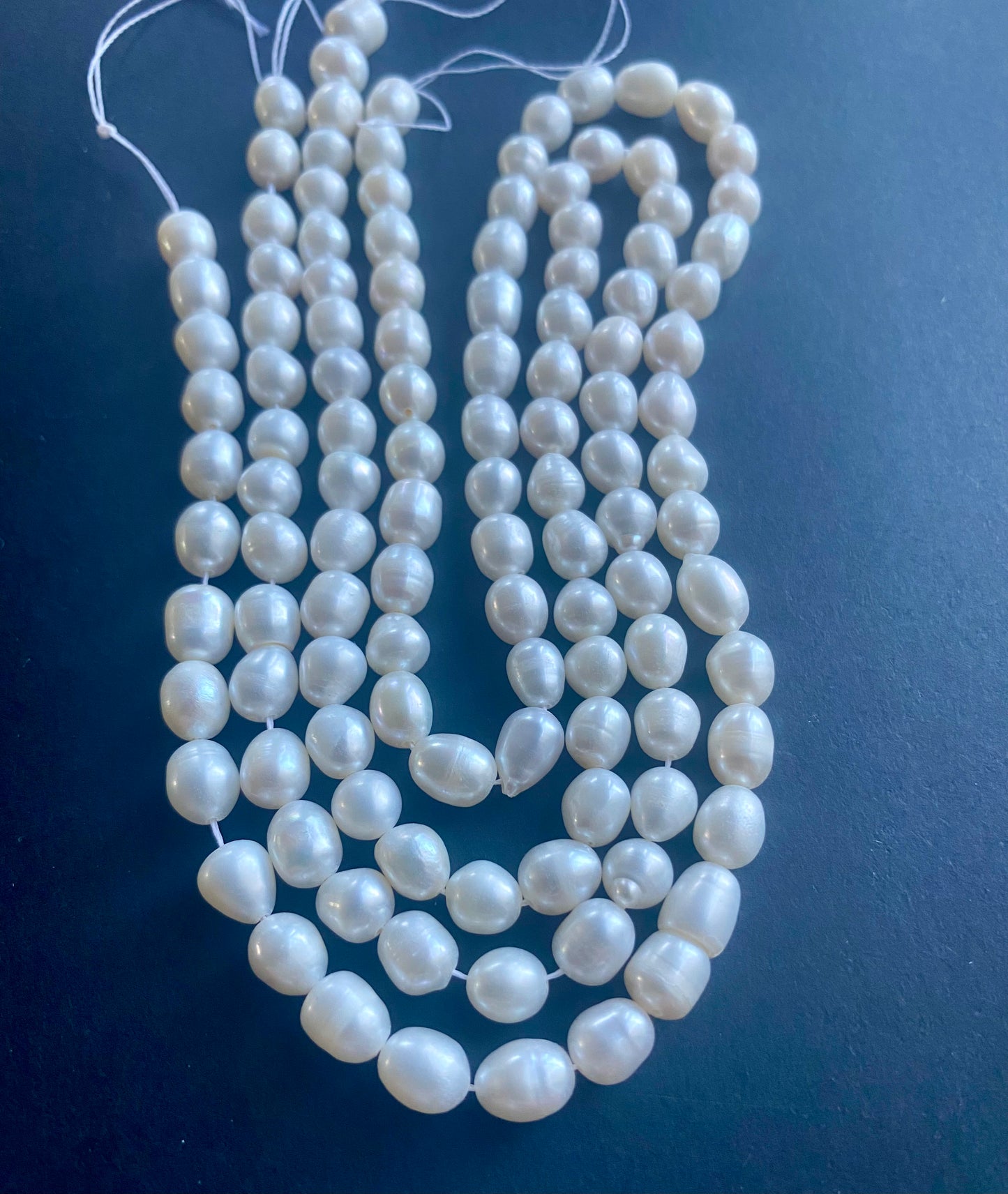 A beautiful arrangement of 6mm white pearls on a smooth table.