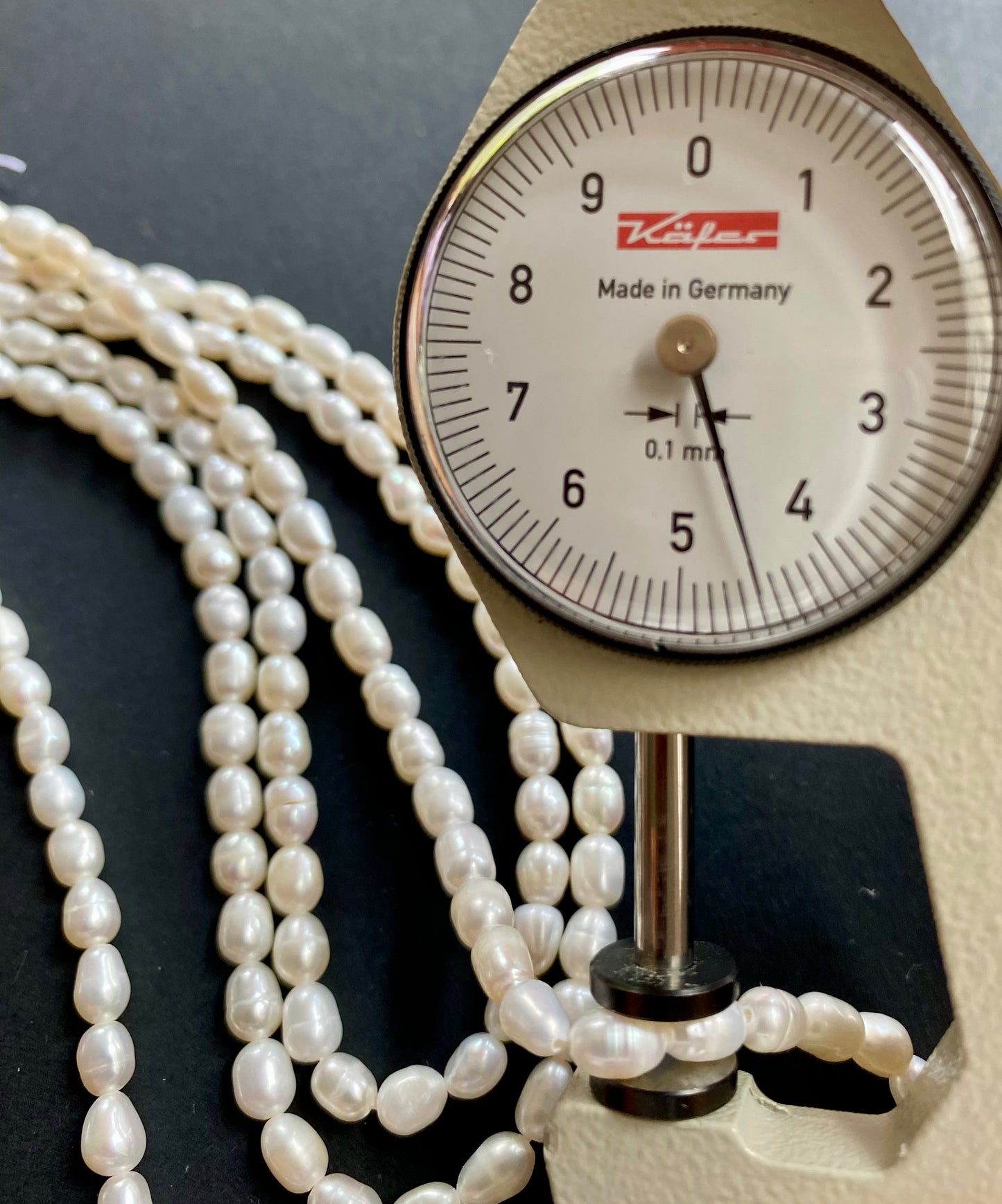 A dial gauge featuring a 4.5mm freshwater pearl strand, showcasing its size and measurement.
