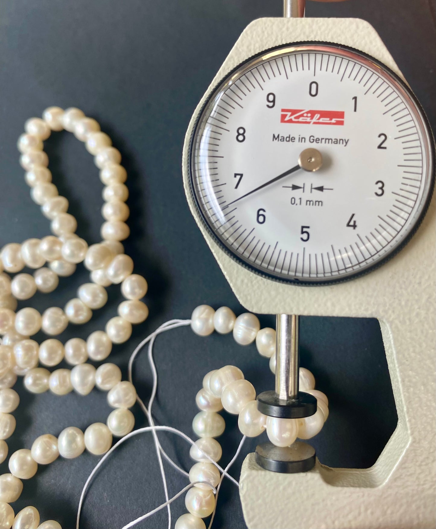 A dial gauge displaying a delicate 6-6.5mm freshwater rice pearl strand, highlighting size and measurement