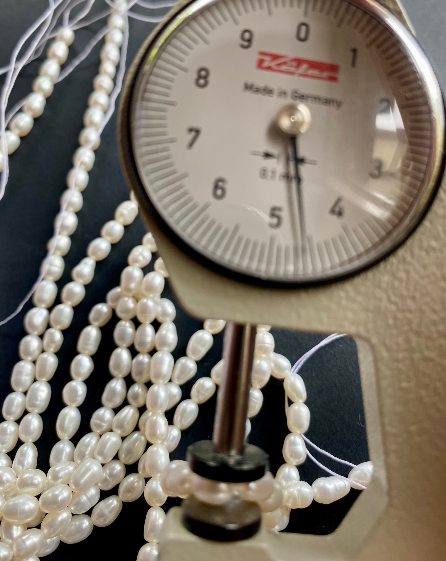 A dial gauge displaying a delicate 4-4.5mm freshwater rice pearl strand, highlighting size and measurement.