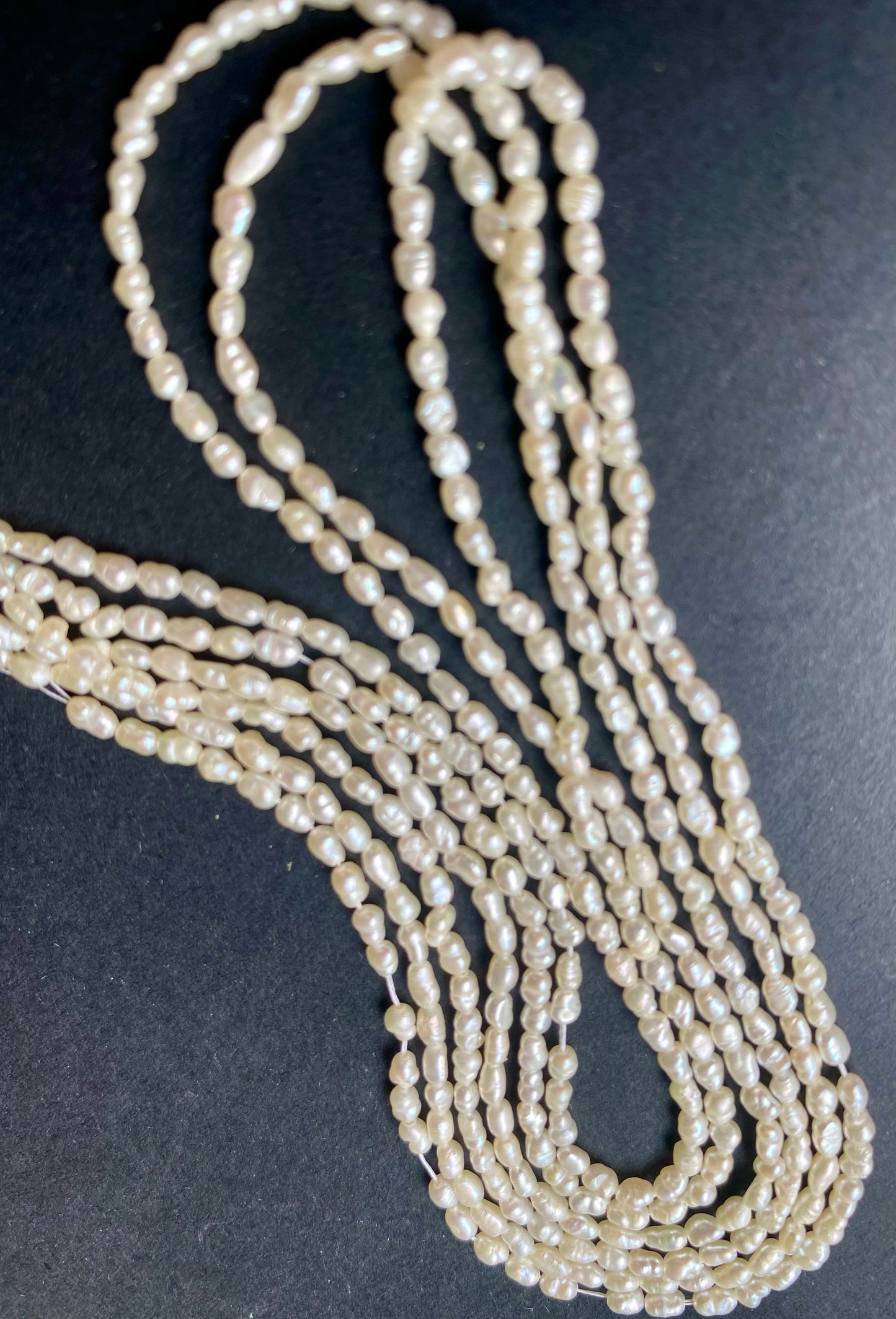 Multi-strands necklace made of 2-2.2mm freshwater rice pearls, showcasing a lustrous and elegant design.