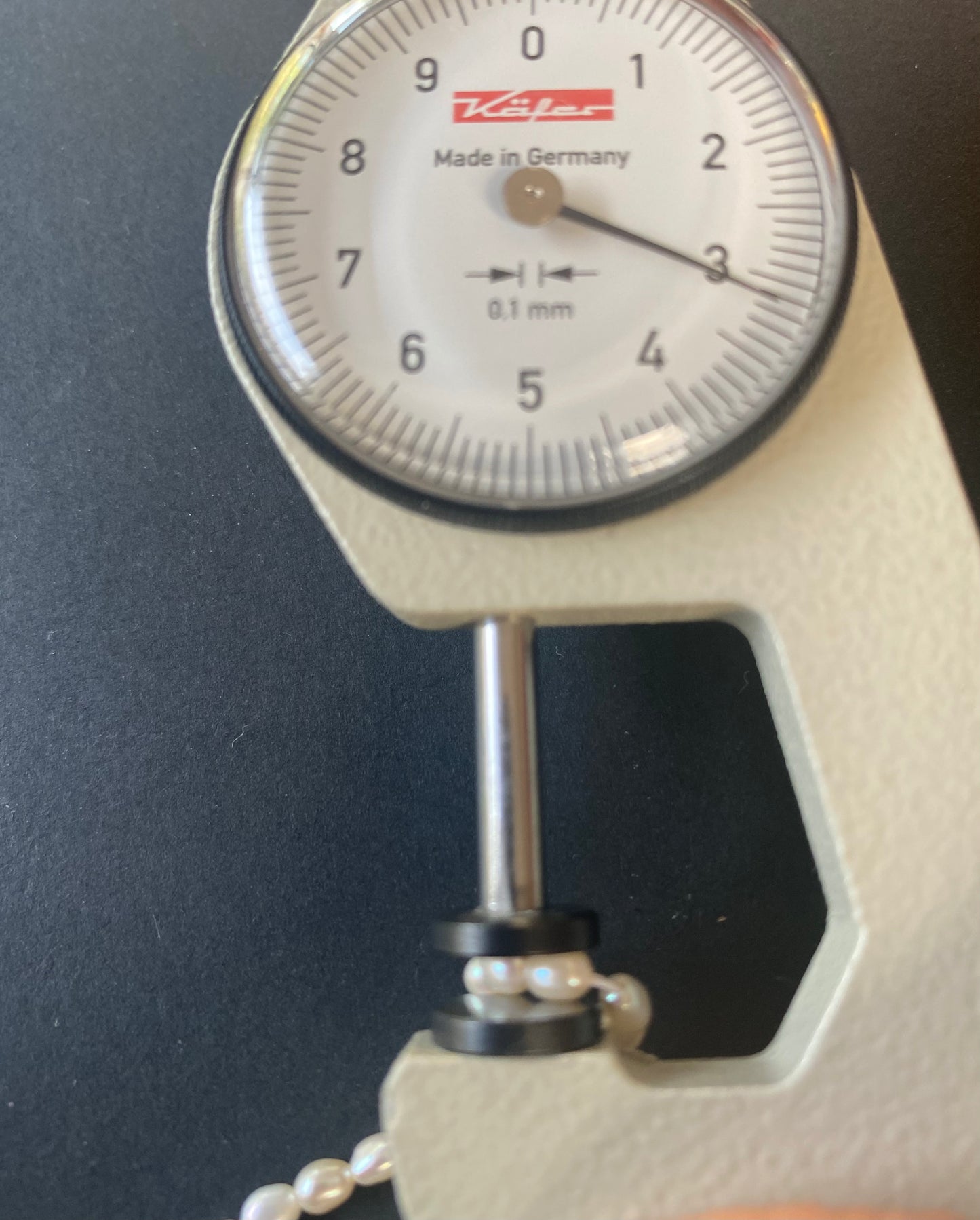 A dial gauge displaying a delicate 3.0-3.2mm freshwater rice pearl strand, highlighting size and measurement