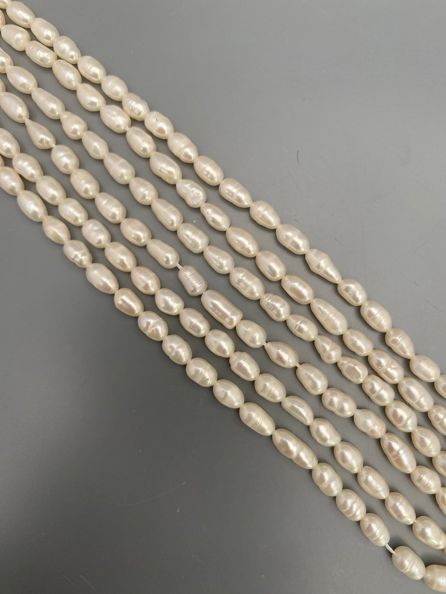 A detailed view of 34cm strands of baroque rice pearls, emphasizing their rich colour tones.