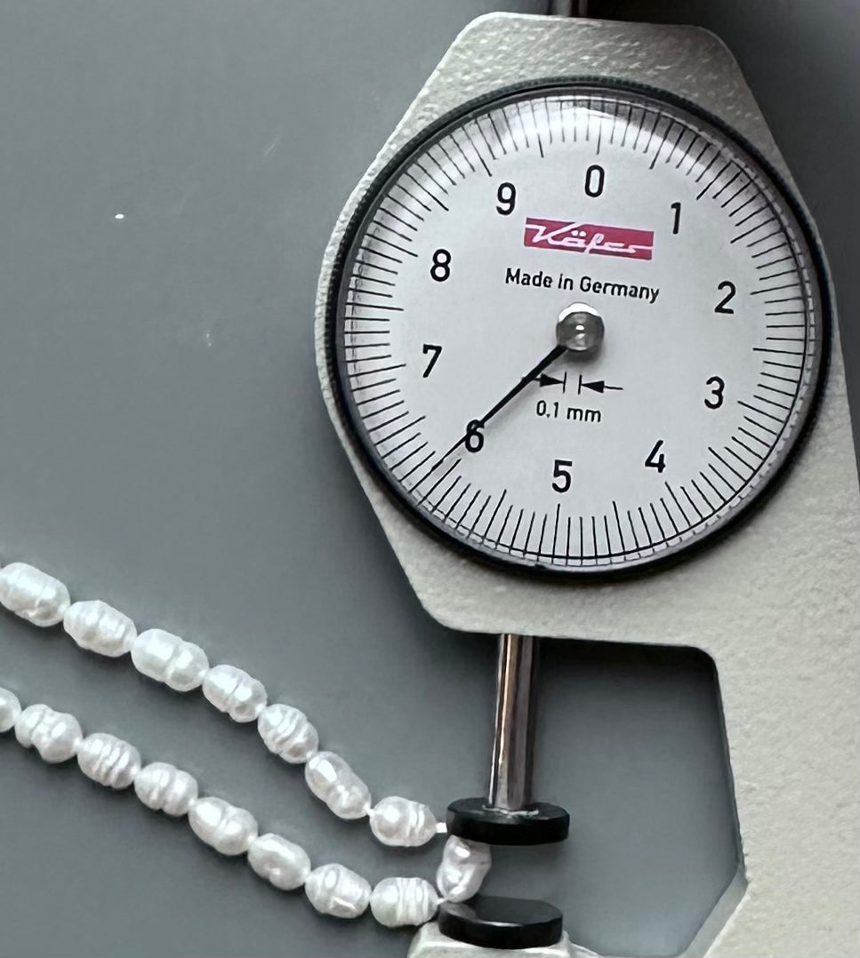 A scale displaying a delicate freshwater rice pearl necklace, highlighting its elegance and beauty.