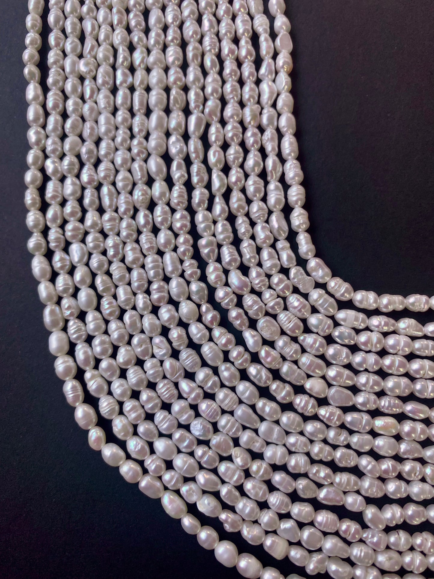 Numerous strands of 3.5-4mm white freshwater rice pearls, exuding elegance and sophistication