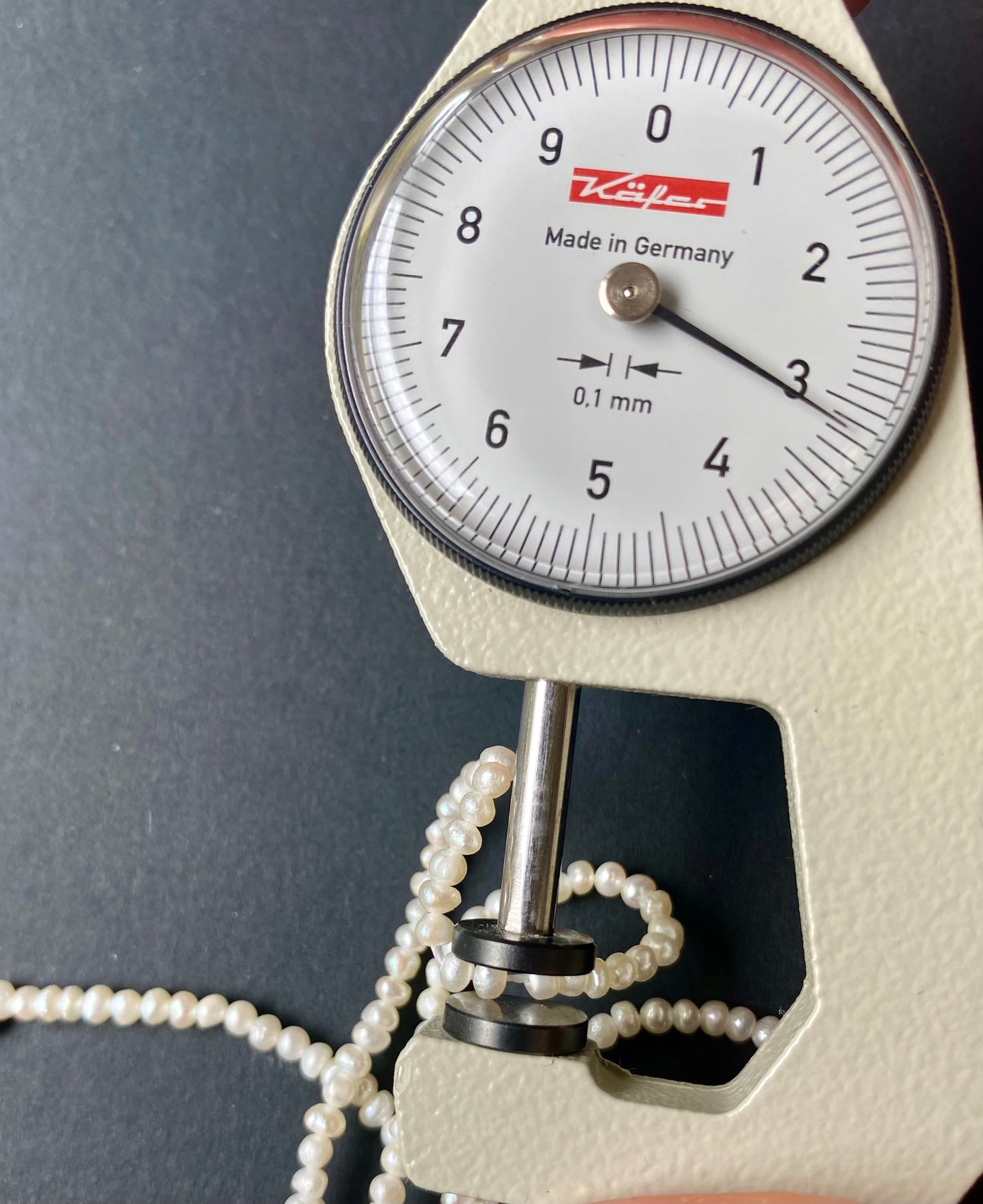 A dial gauge with a pearl bead , showcasing freshwater pearls sized 3mm for precise measurement.
