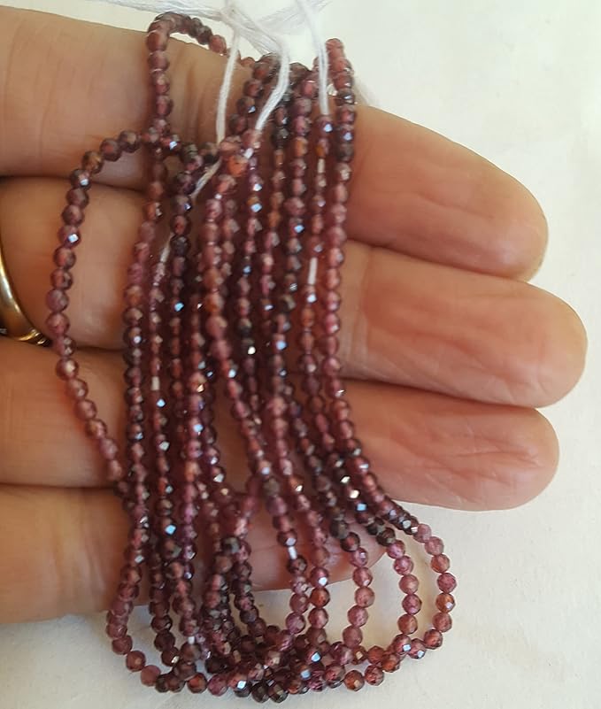 Strands of garnet beads, featuring 2mm faceted rondelle shapes, showcasing their vibrant colour and shine.