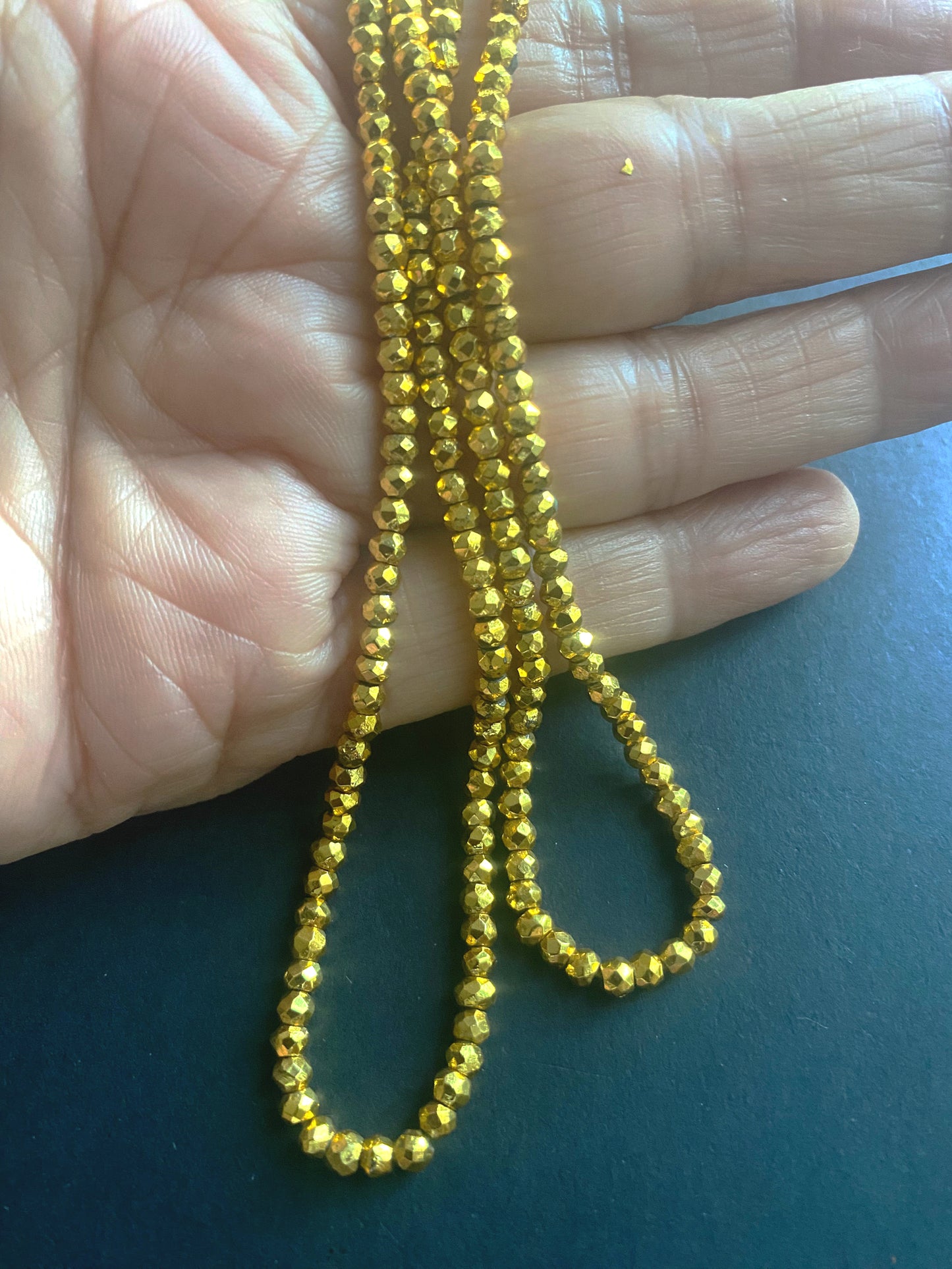Gold Pyrite beads arranged in a cascading pattern, highlighting their rich golden tones.