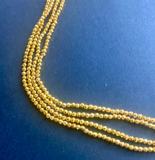 Elegant strands adorned with 3-5mm gold pyrite faceted rondelle beads, showcasing a sleek design.